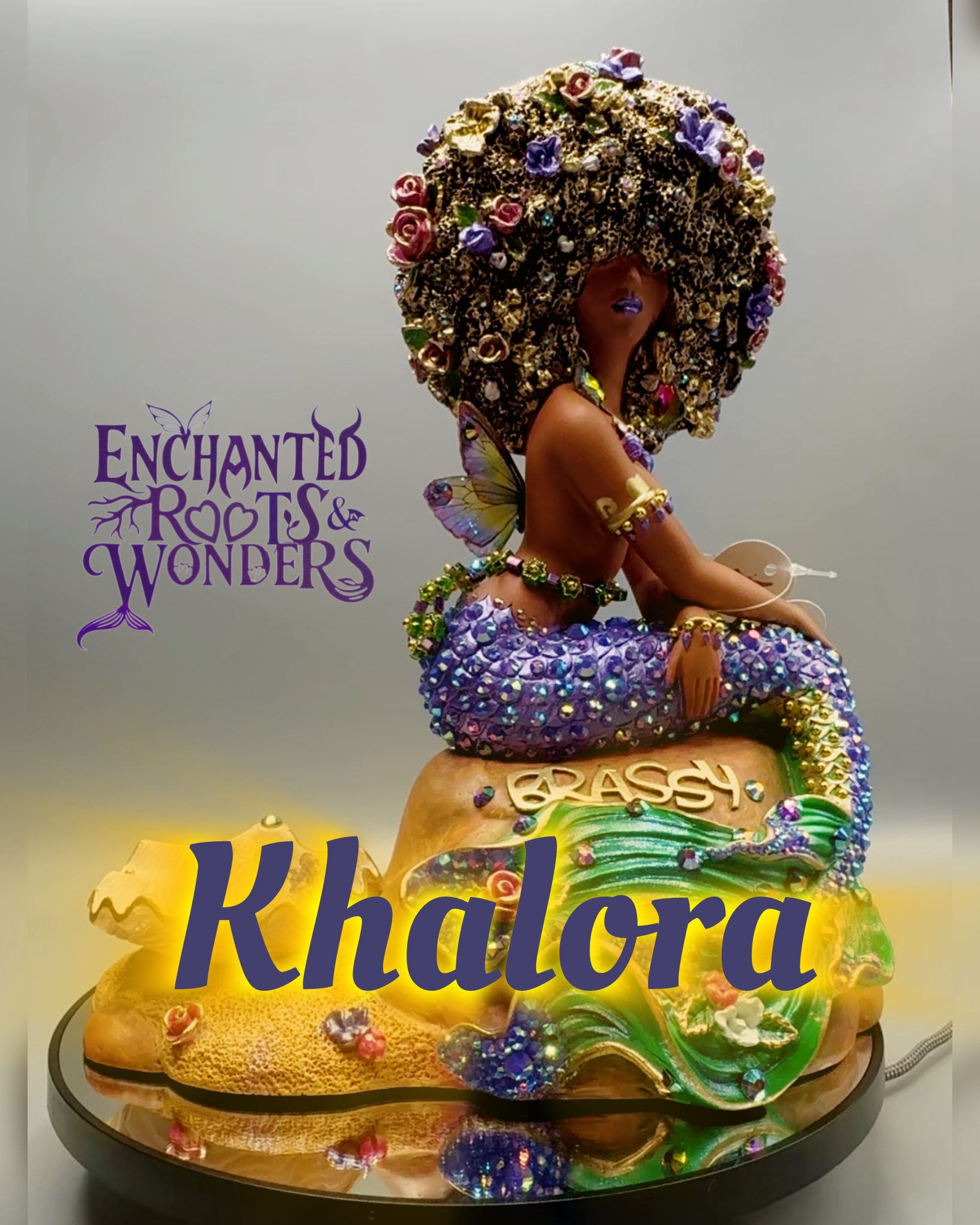 Khalora, a Black mermaid with rich brown skin, a shimmering purple and gold mermaid tail, and delicate fairy wings. A one-of-a-kind Afro Mermaid fantasy statue celebrating Black mermaids, magical artistry, and inclusive fantasy