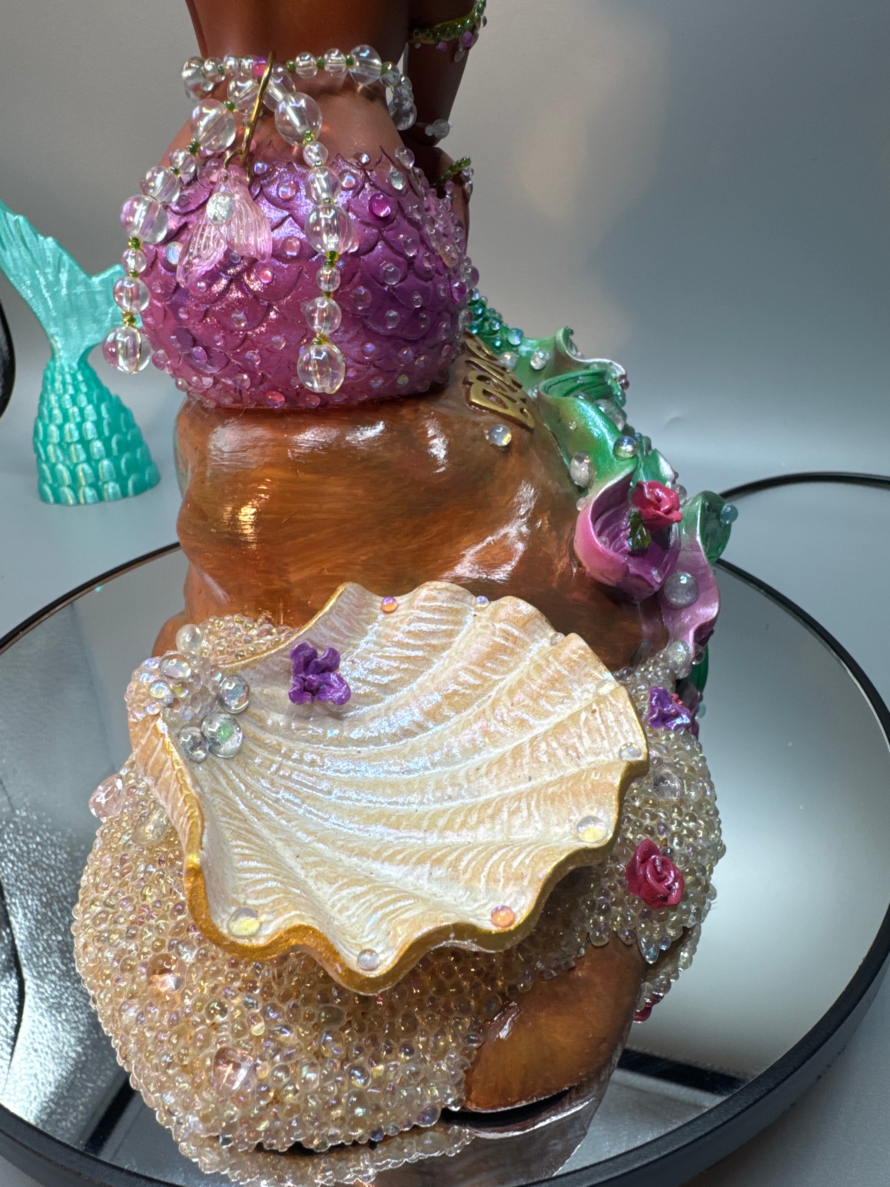 Detail shot of glowing bubbles and sparkling stones around Lumira’s base and Shell, giving the illusion of fresh-from-the-sea wetness. A magical Black mermaid statue from Enchanted Roots & Wonders.
