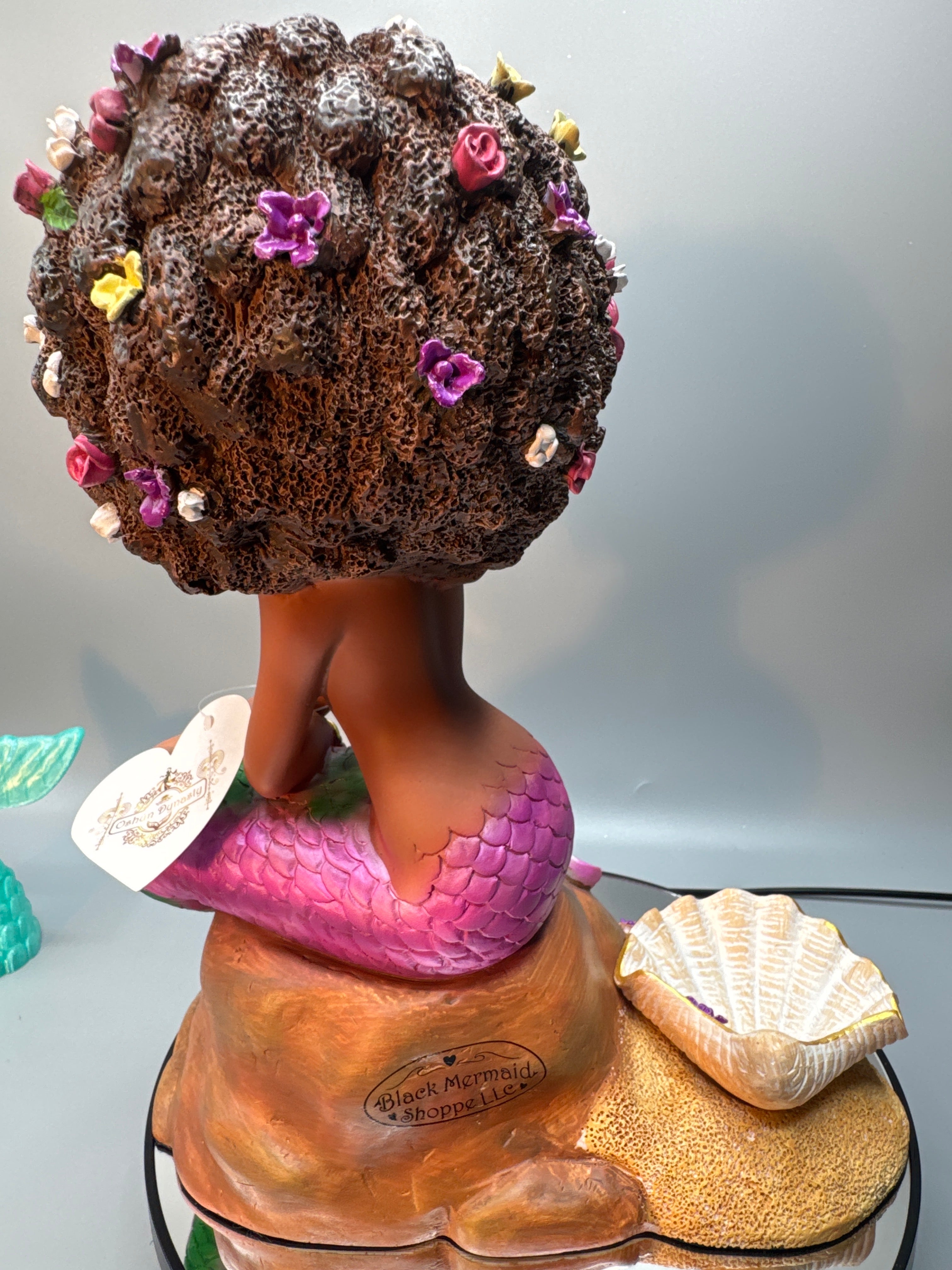 Detail of Brassy’s large textured seashell and golden-sand base with floral accents, showcasing hand-painted realism and shimmer finish.