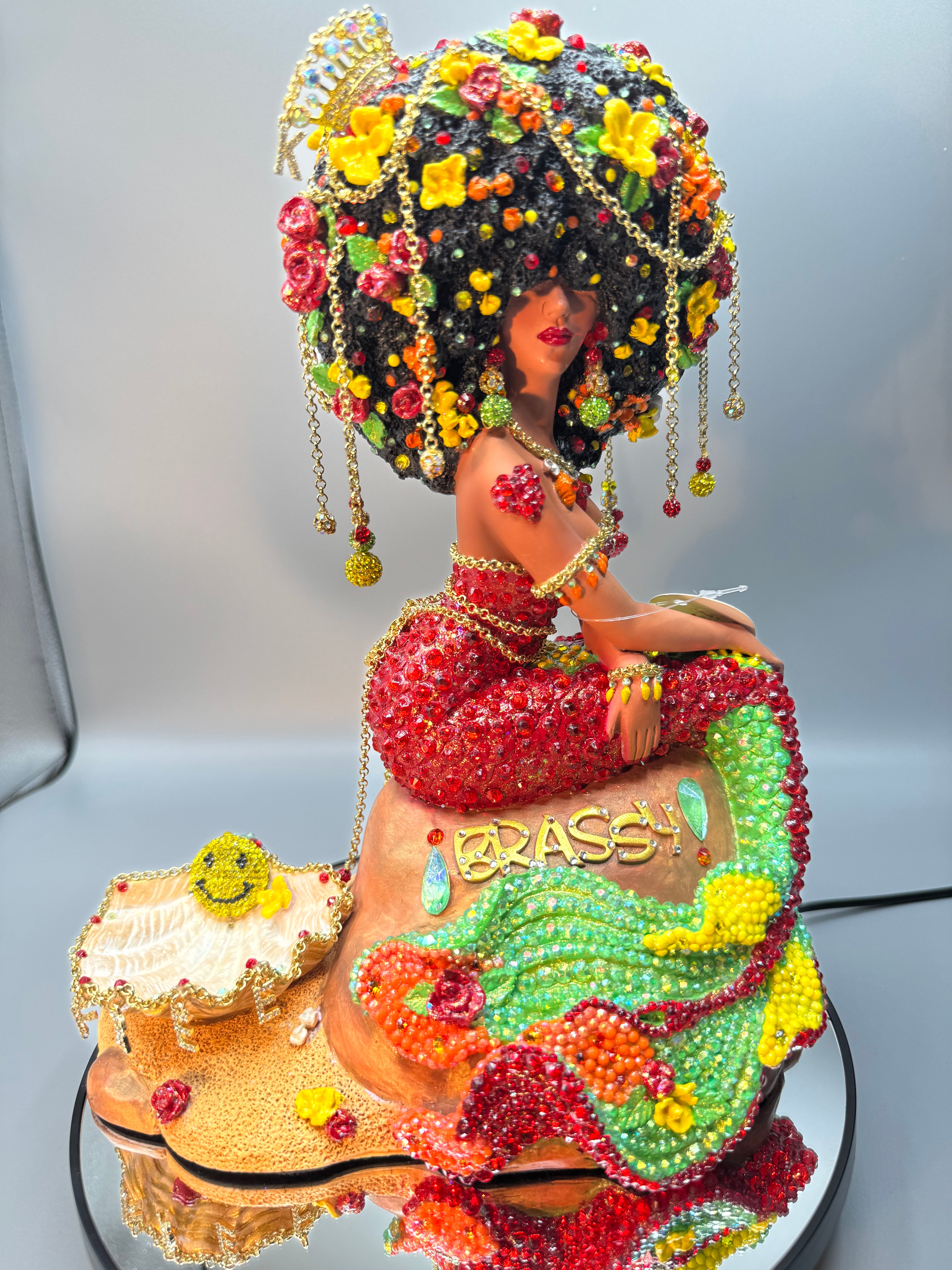 Kalana – OOAK Latina Afro Mermaid statue with vibrant red, yellow, green, and orange rhinestones. Dangling chains, belly chain, “Free” charm, sparkly Afro hair, and a K charm crown. Custom art doll made by Clover Jené Mermaid.