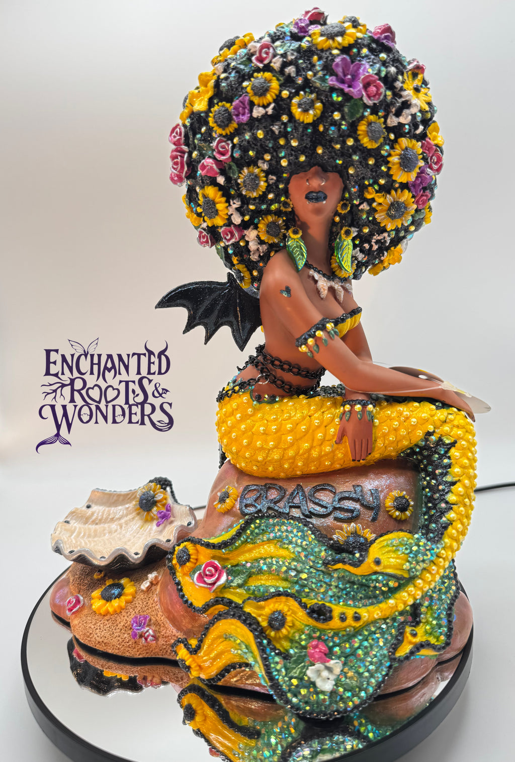 Lómara – a one-of-a-kind goth Black mermaid statue with vampire bat wings and sunflower-filled hair. Yellow and black tail, dark lipstick, and a hauntingly regal look. Custom handmade fantasy sculpture for collectors by Clover Jené Mermaid.