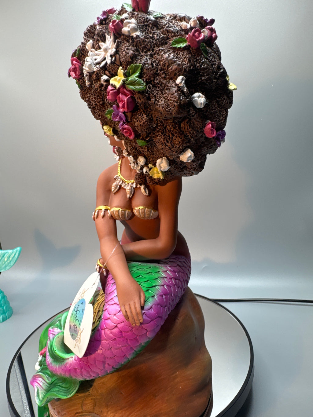 Back view of the Afro Mermaid statue showing her voluminous floral afro, detailed tail sculpt, and vibrant hand-painted flowers and scales.
