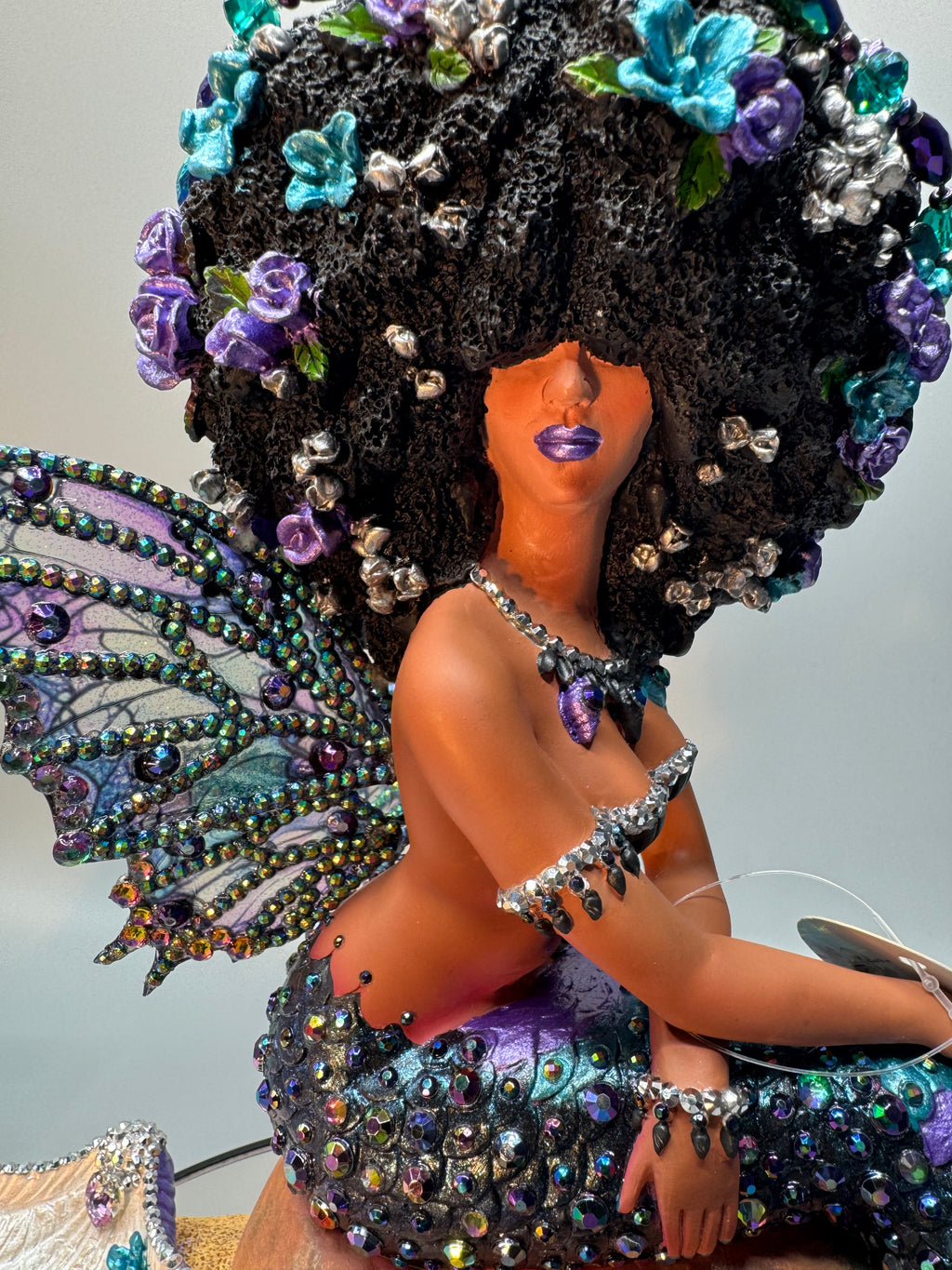 Side view of Oil Slick Brassy Black mermaid statue with rhinestone-embellished wings, hair, and tail