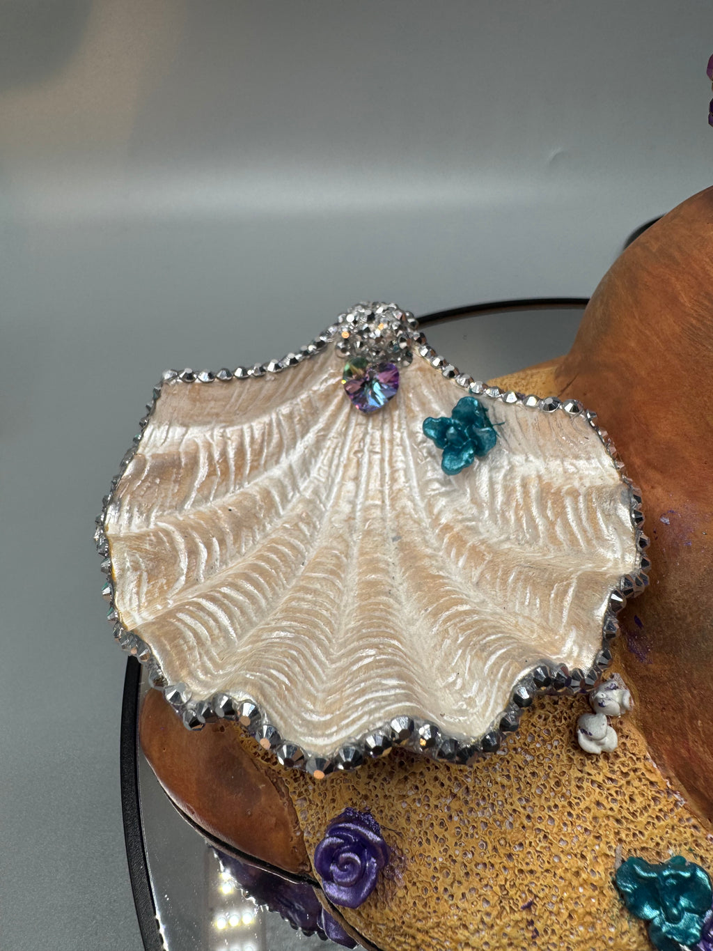 Detail of Oil Slick Brassy decorative shell bowl with rhinestone trim on a hand-painted Black mermaid statue